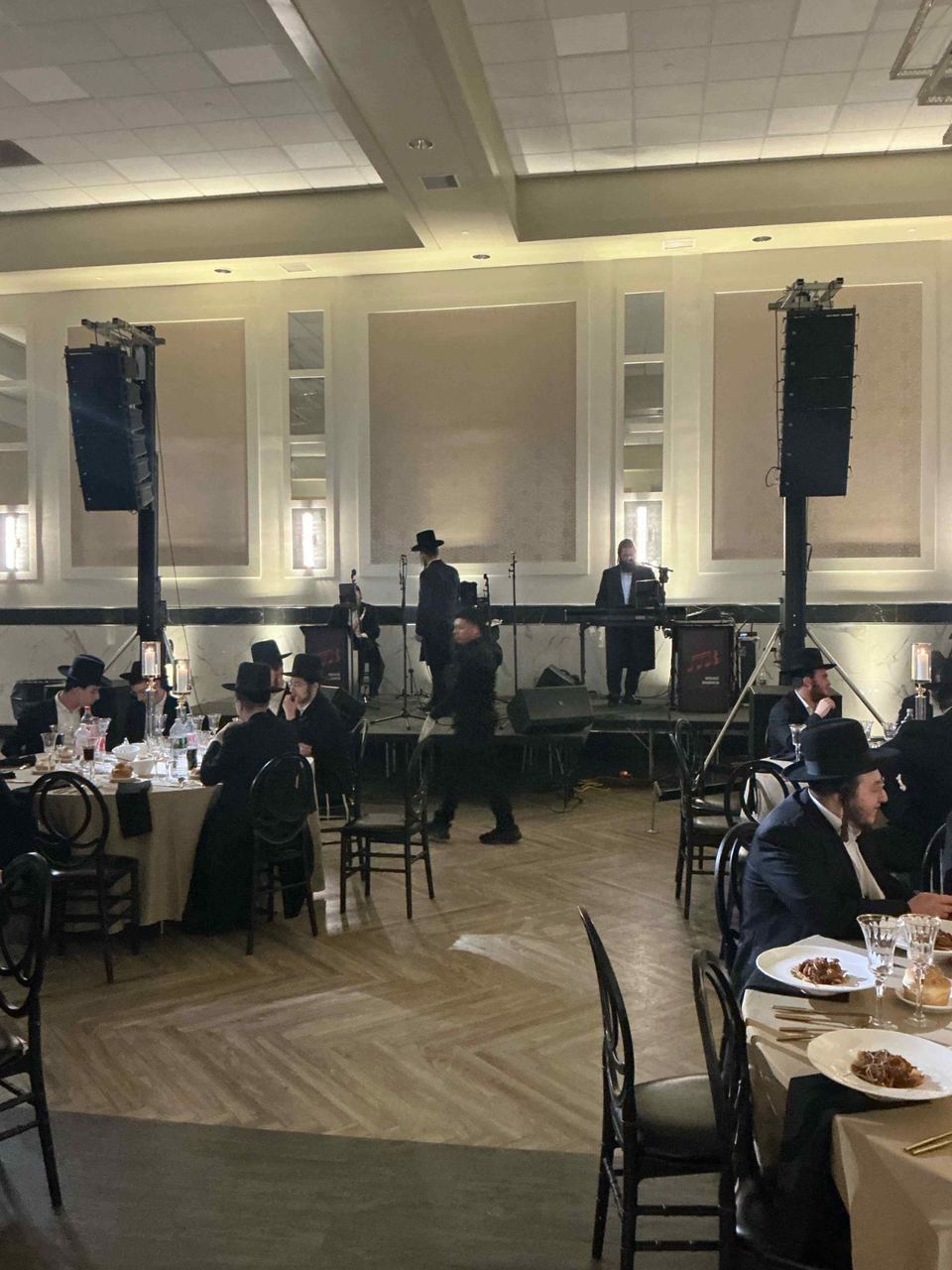 Speakers on stands at the front of a ballroom