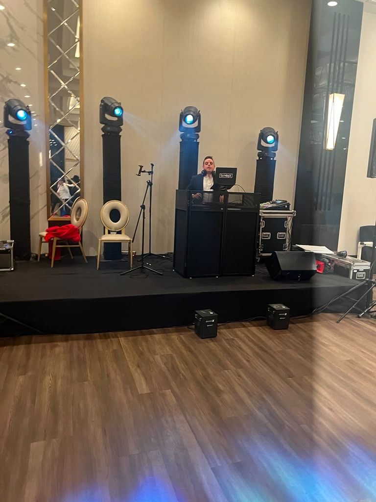 DJ booth with moving-head beams over the dance floor